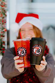 Happy customers reviewing 7 Brew coffee drinks with menu guide and recipe notes on table